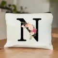 Detailansicht der weißen Kosmetiktasche aus Leinen mit Blumen-Buchstaben N und Reißverschluss. - Buchstabe N