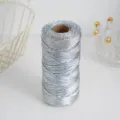 Detail view of metallic silver craft cord twine on spool, perfect for DIY gift wrapping and tags. - Silver