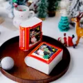 Detail de boite en papier de livre de Noel avec design rouge festif et texte joyeux. - Boîte Unique Emballée à Plat / 10.5*11.5*5cm
