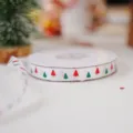 Primo piano dettagliato di un rotolo di nastro bianco con motivi di alberi di Natale. - Nastro Poliestere Albero di Natale / Bianco
