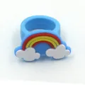 Nahaufnahme des blauen Silikonrings mit niedlichem 3D-Regenbogen- und weißen Wolken-Design. - Einhorn 13