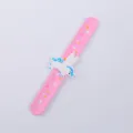 Rosa Silikon Schnapparmband Detail mit süßer weißer Einhorn Figur und bunten kleinen Sternen. - Rosa