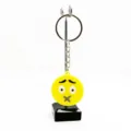 Detailopname van een schattige gele emoji PVC sleutelhanger op een metalen standaard. - Expressie 16