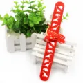 Nahaufnahme des roten Kinder Schnapparmbands mit Dinosaurier Motiven und 3D Spielzeug. - Rot (Dinosaurier Großer Druck)