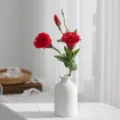 Κόκκινη τεχνητή ανθοδέσμη λυσίανθος σε λευκό κεραμικό βάζο, κομψή διακόσμηση εσωτερικού χώρου. - Κόκκινο