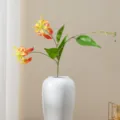 Arrangement de fleurs artificielles de lis gloriosa dans un vase en ceramique blanc. - Or Rouge