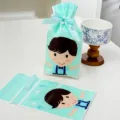Primo piano dettagliato della borsa regalo verde menta con simpatico ragazzo e fiocco blu. - Stile per Ragazzi / 10 Pezzi/Confezione (15*23.5cm)