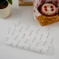 Greaseproof baking paper detail showing stacked sheets with hand made print and food styling. - 50 Pieces/Pack-Handmade