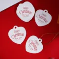 Papieren cadeaulabels in hartvorm van dichtbij met gedrukte kerstwensen voor doe-het-zelvers. - 50 Stuks/Pak / Wit met Rode Letters