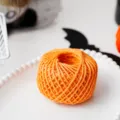 Orange jute twine ball close-up, ideal for handmade DIY craft gift wrapping and holiday decoration. - Orange