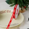 Red Christmas ribbon roll with Merry Christmas print, 1cm wide detail for gift wrapping. - Red