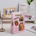 Detailed view of the pink cute cartoon gift paper bag featuring fun capybara and fast food prints. - Pink Capybara / 1 Piece