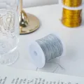 Close-up detail of silver metallic string cord on a spool, perfect for DIY craft and gift wrapping. - 20m Pack / Silver