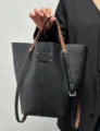 Borsa secchiello in pelle nera con manici marroni e dettaglio a quattro cuciture. - Nero