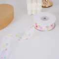Weisses transparentes Band mit bunten Blumen, ideal fuer Geschenkverpackung und Deko. - Blume