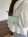 Vista dettagliata della borsa a tracolla trapuntata verde menta con catena e chiusura. - Verde