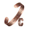 Vintage copper magnetic bracelet and ring set with embossed scroll pattern details. - Set