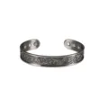 Detailed close-up of men vintage magnetic copper cuff bracelet with carved tribal pattern. - Silver