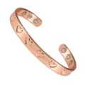 Detailed close-up of the adjustable copper magnetic cuff bracelet with engraved heart pattern. - Bangle / Copper