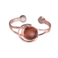 Detailed view of copper magnetic cuff bracelet with moon sun design and brown gemstone. - Brown - Artificial Stone