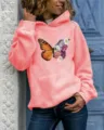 Nahaufnahme der Schmetterlings- und Blumen-Brustgrafik auf dem pfirsichfarbenen Kapuzenpullover. - Rosa mit Kapuze