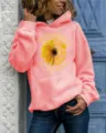 Detail view of women's coral pink hoodie featuring unique sunflower skull graphic print. - Pink