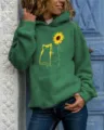 Green hoodie featuring a cute cat and sunflower graphic print with long sleeves and cozy hood. - Green