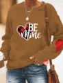 Vista detallada de la sudadera marrón de manga larga con estampado de corazones y parche. - Caqui