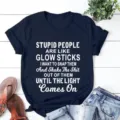 Detailed view of dark blue short sleeve t-shirt with funny quote print on wooden flat lay. - Navy Blue