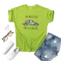 Close-up detail of the vintage car graphic print and slogan on the casual summer green t-shirt. - S / Tops / Green