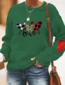 Green sweatshirt sleeve detail showing heart patch, casual long sleeve pullover fashion. - Green