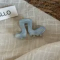 Gros plan sur la pince à cheveux en acétate bleue, forme chenille mignonne, accessoire. - Bleu