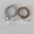 Detail view of telephone cord hair ties with mobile phone tether tabs and metal rings, multi-purpose. - Dopamine Telephone Cord Silver Card