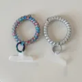 Gradient rainbow and silver telephone wire hair ties with metal rings and tether tabs for phone. - Dopamine Telephone Cord Silver Gray