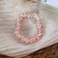 Silk scrunchie detail view, pink satin hair tie showing soft glossy fabric texture. - Light Pink