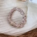 Silk scrunchie detail view, elegant champagne satin hair tie for daily fashion use. - Nude Pink