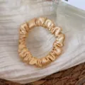 Silk satin hair scrunchie detail shot, elegant golden hair tie for women daily styling. - Yellow