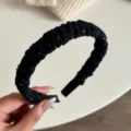 Dettaglio del cerchietto plissettato nero con trama in tessuto e pois colorati. - Pois Colorati Nero