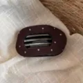 Gros plan de la pince à cheveux en tissu marron à pois montrant une texture douce et des dents. - Pince à Cheveux Pois Café
