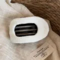 Vue détaillée de l'accessoire de coiffure en tricot blanc, douce texture et beau design. - Pince à Cheveux Rayée Gaufrée / Blanc