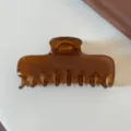 Primo piano dettagliato di un elegante fermaglio per capelli marrone con finitura lucida. - Marrone Caramello - Grande Pinza Rettangolare