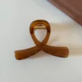 Primo piano dettagliato di un elegante fermaglio per capelli marrone traslucido e chic. - Marrone Caramello - Pinza Incrociata