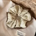 Gedetailleerd overzicht van grote stippen haarscrunchie met bruine rand, zachte stof. - Donkerbruine Rand Scrunchie / Beige Zwarte Punten