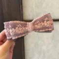Vue détaillée d'une pince à cheveux nœud en dentelle rose avec des couches de résille. - Rose Maille de Dentelle - Pince à Ressort