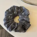 Elastico per capelli a quadri grigio scuro, dettaglio del tessuto, elegante accessorio quotidiano. - Chouchou a Quadri / Grigio