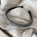 Primo piano dettagliato di un cerchietto in tessuto grigio fantasia su lino. - Cerchietto Stretto Floreale / Grigio