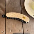 Détail de pince à cheveux banane tissée exquise avec élégant accent en métal doré. - Pince Banane / Beige