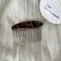 Primer plano detalle de un elegante peine para el cabello con estampado de leopardo y metal. - Peineta de Satén Leopardo