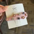 Primo piano sul dettaglio del fermaglio per capelli con fiori di strass rosa, accessorio lucido - Rosa
