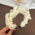 Vue détaillée du serre-tête beige plissé en gaze avec longues dents et perles sombres. - Serre-tête En Maille De Cristal Perlé / Beige
